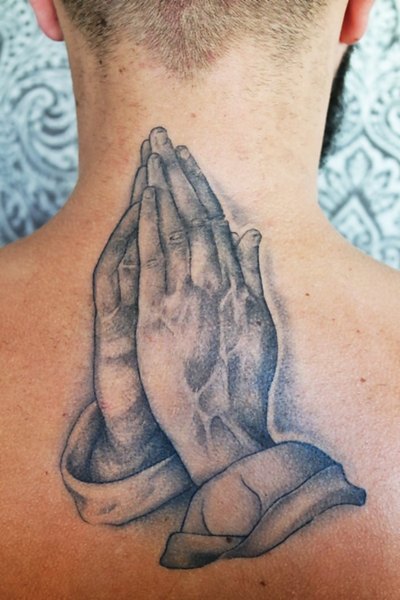 Mains en pri&egrave;re tatou&eacute;es sur la nuque &mdash; pi&egrave;ce signature